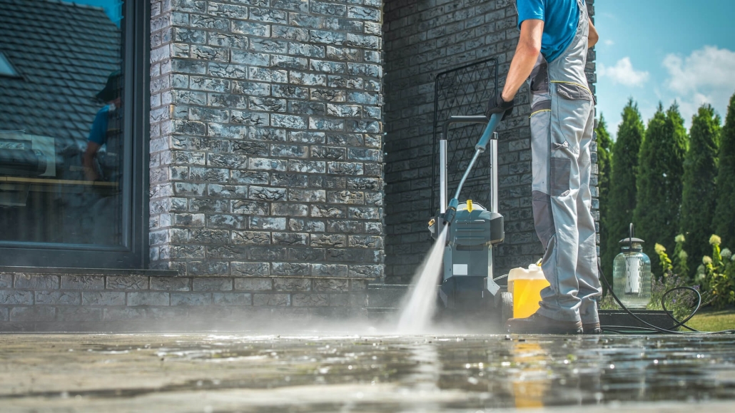 man pressure washing outdoor pavers